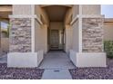 Inviting entryway with stone accents and a covered porch at 14837 W Crocus Dr, Surprise, AZ 85379