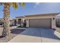 Well-maintained home featuring an attached two-car garage and desert landscaping at 14837 W Crocus Dr, Surprise, AZ 85379