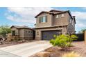 This two-story home features neutral stucco siding, a tile roof, dark garage door, and desert landscaping in the front yard at 1525 W Bent Tree Dr, Phoenix, AZ 85085