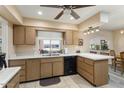 Bright kitchen featuring a double sink, black dishwasher, and ample counter space, perfect for meal preparation at 15621 N Lakeforest Dr, Sun City, AZ 85351