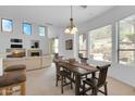 Bright dining area featuring a wooden table, modern lighting, and views into living space at 16420 N Thompson Peak Pkwy # 1064, Scottsdale, AZ 85260