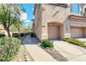 Landscaped townhome corner featuring mature trees, xeriscaping, and convenient two-car garage access at 16420 N Thompson Peak Pkwy # 1064, Scottsdale, AZ 85260