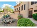 Home exterior with desert landscaping of rocks, bushes and cacti adding to the home's curb appeal at 16420 N Thompson Peak Pkwy # 1064, Scottsdale, AZ 85260