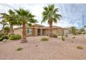 Desert-landscaped home with palm trees, adding a unique touch to the Southwest-style architecture at 17335 W Gould Mine Ln, Surprise, AZ 85387