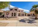 Two-story home featuring desert landscaping, warm earthy tones, tile roof, and an extended driveway at 17423 W Yavapai St, Goodyear, AZ 85338