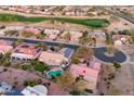 Aerial view of houses near golf course, showcasing lush green landscape, community, and a private pool at 17882 N Painted Spurge Ct, Surprise, AZ 85374