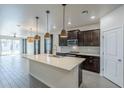 Bright kitchen features a center island with sink, stainless appliances and pendant lighting at 1881 S 223Rd Dr, Buckeye, AZ 85326