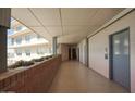 Hallway entrance with elevator access featuring brick details and potted plants at 2201 N Central Ave # 11A, Phoenix, AZ 85004