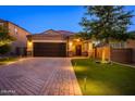 Beautiful single-Gathering home with a two-car garage, brick driveway, and manicured front yard landscaping at 29219 W Clarendon Ave, Buckeye, AZ 85396