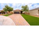 Charming single-Gathering home featuring a two-car garage, lovely brick driveway, and lush landscaping at 29219 W Clarendon Ave, Buckeye, AZ 85396