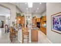 Open kitchen features granite countertops, wood cabinetry, recessed lighting, and a breakfast bar at 3108 W Ravina Ln, Anthem, AZ 85086