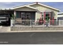 Charming single-story home featuring a covered porch with a white picket fence and outdoor seating at 3504 N Hawes Rd # 3504, Mesa, AZ 85207