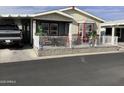 Charming single-story home featuring a covered porch with a white picket fence and outdoor seating at 3504 N Hawes Rd # 3504, Mesa, AZ 85207