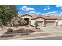 Charming single-story home featuring a tile roof, well-manicured landscaping, and a three-car garage at 4618 E Carriage Ct, Gilbert, AZ 85297