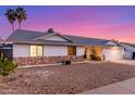 Single-story home showcasing desert landscaping, stone veneer accents, and attached two-car garage at 6237 E Inglewood St, Mesa, AZ 85205