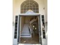 Elegant entryway with a curved staircase and a large window above the door, showcasing a bright and welcoming foyer at 6834 E Culver St, Mesa, AZ 85207