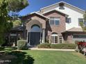 Two-story brick and stucco home featuring a manicured lawn and mature landscaping at 6834 E Culver St, Mesa, AZ 85207