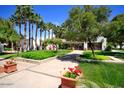 Community entrance features walkway, mature trees, and colorful flowerbeds at 7350 N Via Paseo Del Sur -- # O212, Scottsdale, AZ 85258