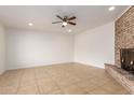 Bright living room featuring tile floors, a ceiling fan, a large brick fireplace, and recessed lighting at 8014 N 55Th Ave, Glendale, AZ 85302