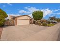 Suburban house with a spacious driveway, two-car garage, and manicured front yard with mature trees at 812 W Rosal Pl, Chandler, AZ 85225