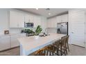 Beautiful kitchen featuring a large island with seating, stainless appliances, and crisp white cabinets at 9918 E Tahoe Ave, Mesa, AZ 85212