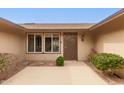 Inviting home entrance featuring a decorative door and lush, manicured shrubbery at 9946 W Willow Creek Cir, Sun City, AZ 85373