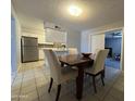 Bright dining area with a wooden table and chairs next to an updated kitchen with stainless steel appliances at 1210 E Marny Rd, Tempe, AZ 85288