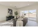 Cozy living room featuring stylish furniture, a large window, and neutral decor at 15580 S 181St Ln, Goodyear, AZ 85338