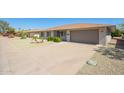 Home exterior displaying desert landscaping, an extended driveway, and attached two-car garage at 16413 N Orchard Hills Dr, Sun City, AZ 85351