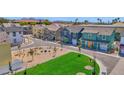 New home community featuring colorful homes, common green space, seating, and landscaped areas with young shade trees at 16875 N 12Th St # 3, Phoenix, AZ 85022