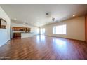 Open-concept living room with wood floors and lots of natural light, adjacent to the kitchen at 18178 W Desert View Ln, Goodyear, AZ 85338