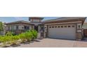 View of the home's exterior highlighting the driveway, two-car garage, and desert landscaping at 18925 W Windsor Blvd, Litchfield Park, AZ 85340