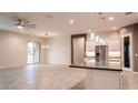 Open-concept living space with tile floors, modern lighting, and seamless flow to the kitchen area at 18925 W Windsor Blvd, Litchfield Park, AZ 85340