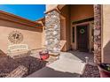 Welcoming front entrance featuring a decorative metal door, stone column, and manicured landscaping at 1926 W Wayne Ln, Anthem, AZ 85086