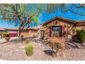 Inviting home with desert landscaping, stone accents, and a lush tree, offering curb appeal at 1926 W Wayne Ln, Anthem, AZ 85086