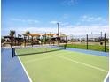 Well-maintained tennis court with green and blue surfaces, surrounded by landscaping and a clear blue sky at 20901 S 231St Way, Queen Creek, AZ 85142