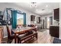 Cozy dining area with a wooden table and bench, complemented by stylish curtains and natural light at 2376 E Rosario Mission Dr, Casa Grande, AZ 85194