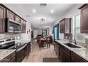 Open kitchen featuring stainless steel appliances, dark cabinetry, granite countertops, and modern lighting at 2376 E Rosario Mission Dr, Casa Grande, AZ 85194