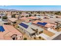 Aerial view of a suburban home with solar panels, surrounded by other homes and desert landscaping at 23830 W Romley W Ave, Buckeye, AZ 85326