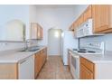 Functional kitchen layout with light wood cabinetry and essential white appliances at 2439 W White Feather Ln, Phoenix, AZ 85085