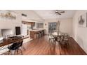 Open-concept living space with wood floors, a ceiling fan, and an adjacent breakfast bar and kitchen at 2512 N Central Dr, Chandler, AZ 85224