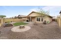 Well-kept backyard featuring a covered patio, artificial turf, desert landscaping, and a fire pit area at 2748 W Sunland Ave, Phoenix, AZ 85041