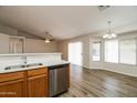 Open-concept living and kitchen area featuring stainless steel appliances, sleek countertops, and modern light fixtures at 40144 N Lerwick Dr, San Tan Valley, AZ 85140