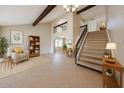 Open living area with high ceilings, staircase, beams, and neutral decor exudes elegance at 4523 W Bluefield Ave, Glendale, AZ 85308