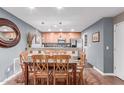 Open dining room area featuring hardwood floors and decorative wall art with kitchen in the background at 4704 E Paradise Village Pkwy # 213, Phoenix, AZ 85032