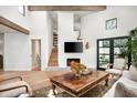 Living room view with fireplace, mounted television, and view of staircase and backyard through French doors at 5101 N Casa Blanca Dr # 217, Paradise Valley, AZ 85253