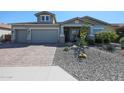 Charming single-story home featuring a two-car garage, desert landscaping, and a welcoming front entrance at 5621 N 189Th Dr, Litchfield Park, AZ 85340