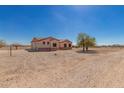 Desert home on expansive lot with neutral toned exterior and xeriscaping at 6431 N 418Th Ave, Tonopah, AZ 85354