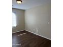 Bedroom with wood-look floors, neutral paint and natural light from the bright window at 6819 S 38Th Dr, Phoenix, AZ 85041