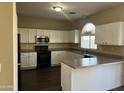 Well-lit kitchen featuring modern black appliances, ample white cabinetry and a breakfast bar at 6819 S 38Th Dr, Phoenix, AZ 85041